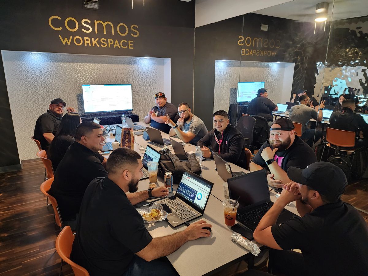 People collaborating around a table inside Cosmos Workspace in McAllen